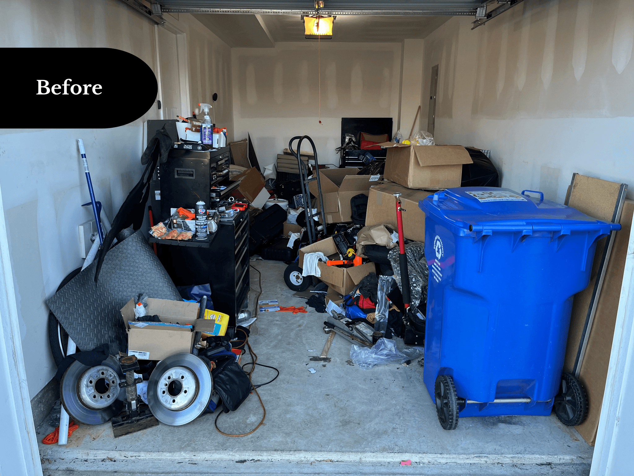 Cluttered one-car garage filled with stored items, before transformation